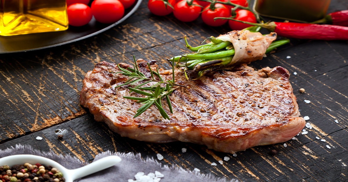 Fresh grilled meat. Grilled beef steak medium rare on wooden cutting board. Top view.
